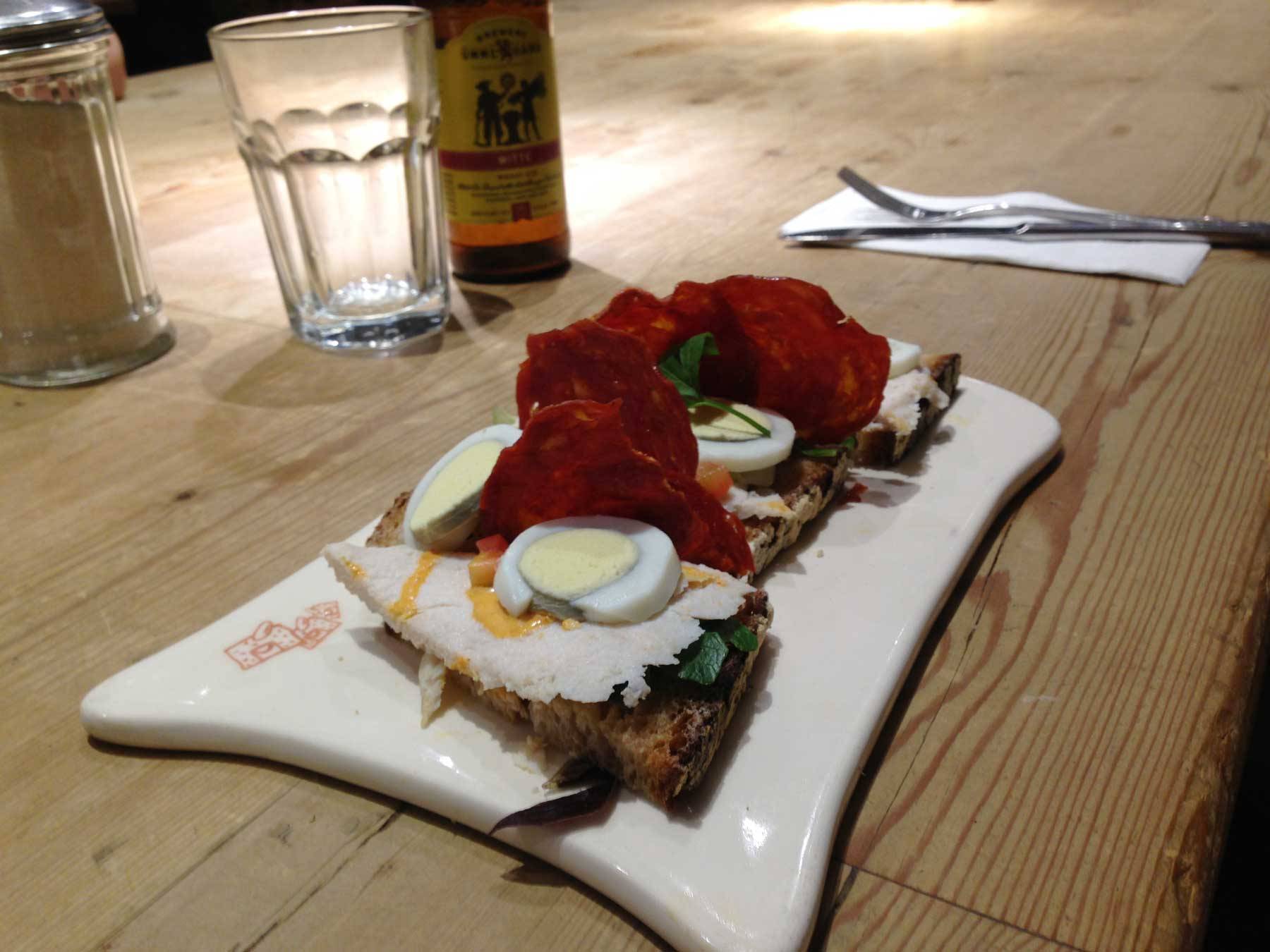 An open faced sandwich with slices of chicken and egg