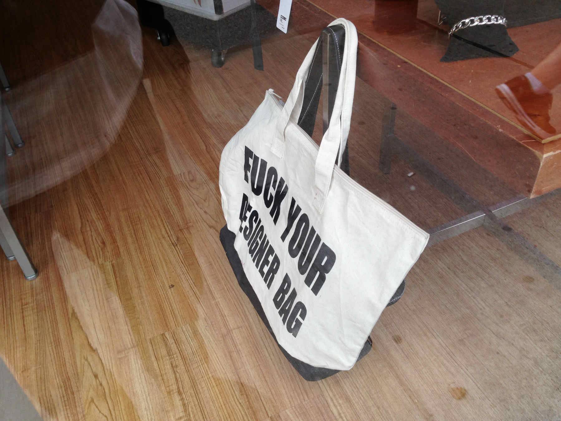Calico bag saying “Fuck your designer bag”