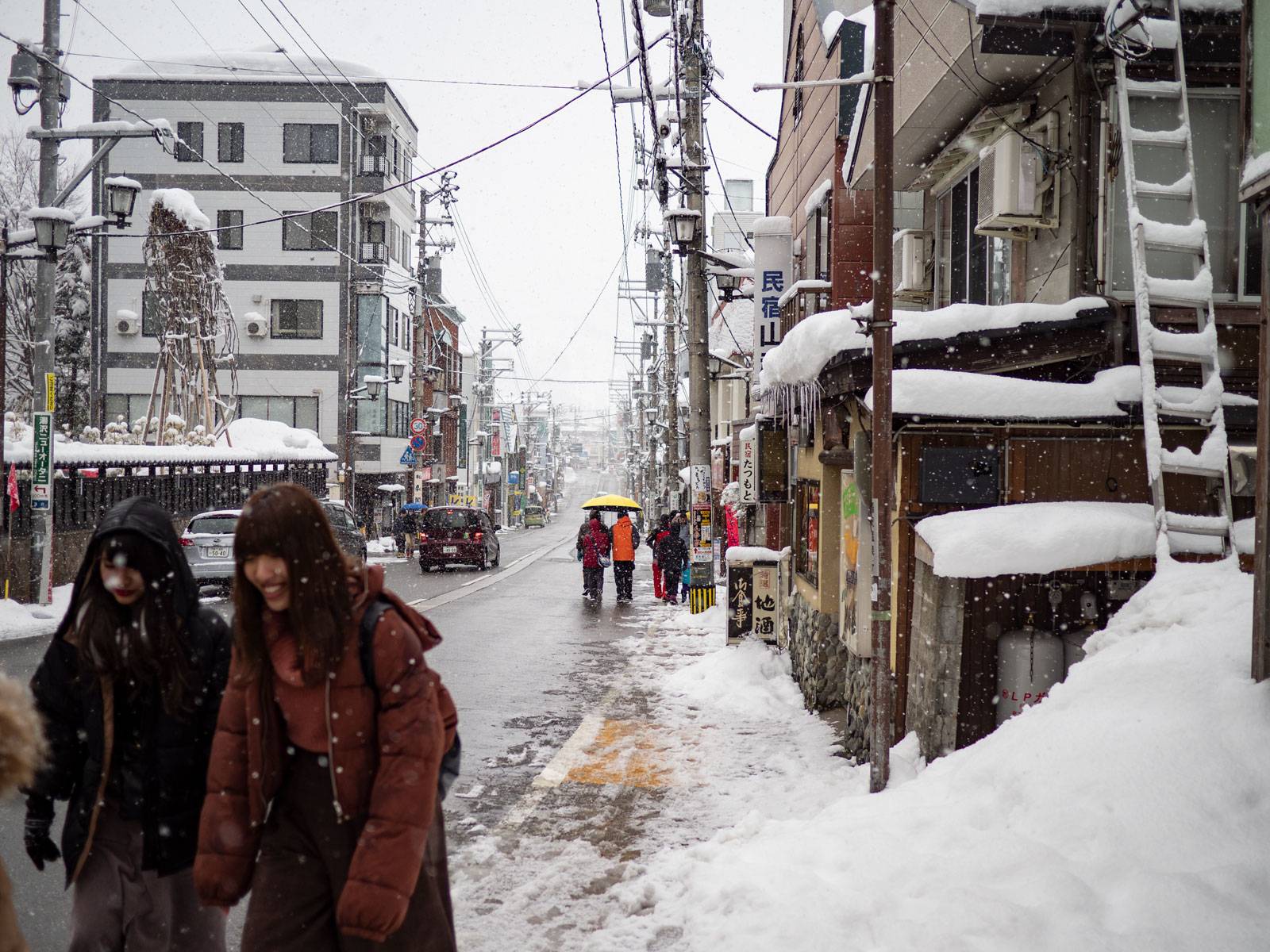 Pedestrians making their way along the snowy sidewalk