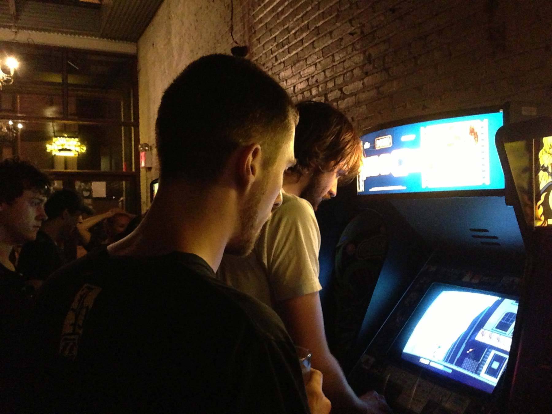 Irwin and Richard watching Butcher play an arcade game