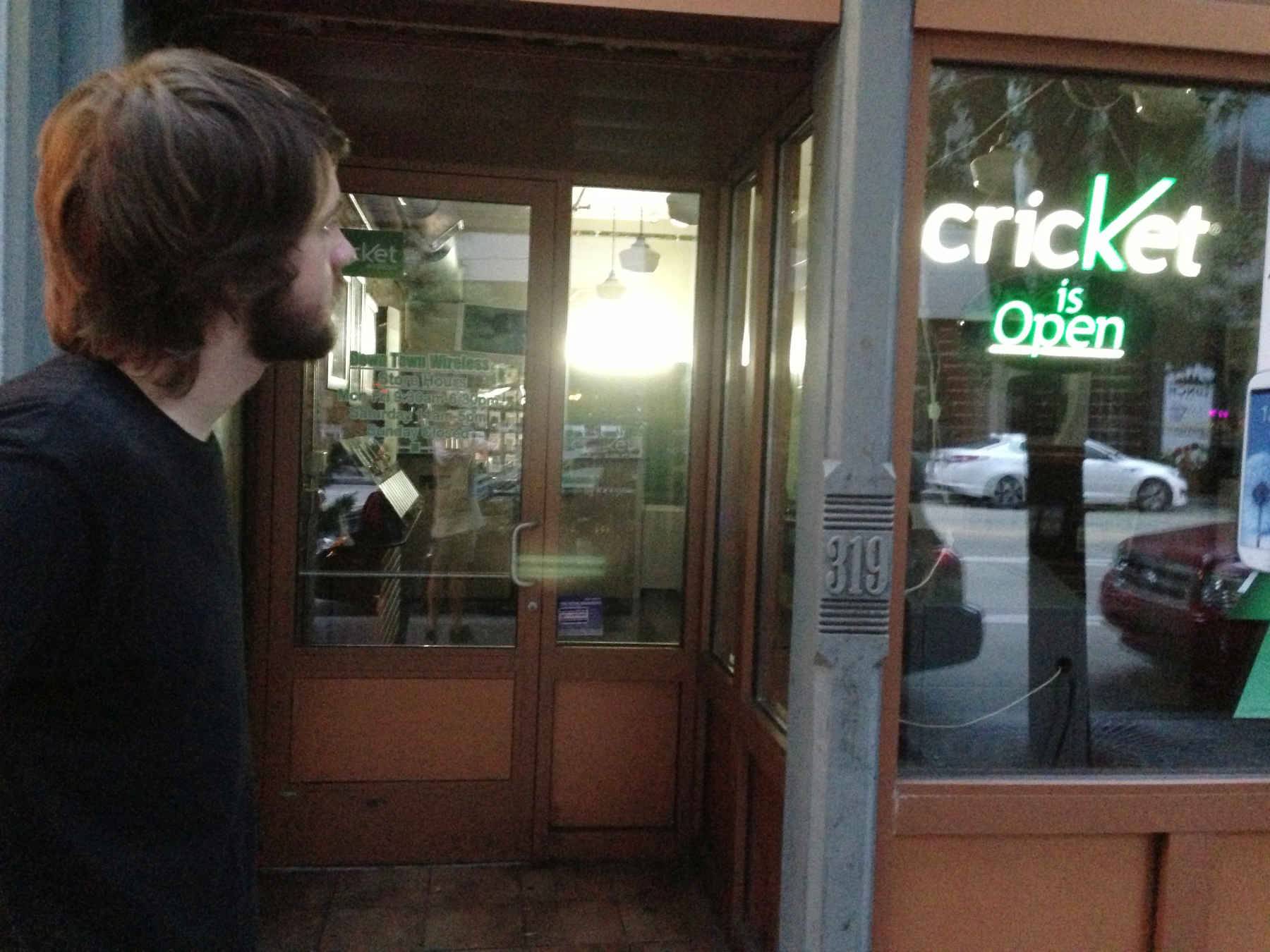 Butcher outside a store saying “Cricket is open”